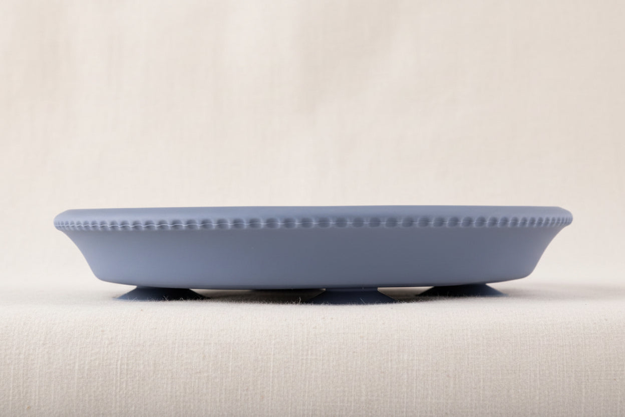 Blue silicone and stainless-steel gripper plate. Side view with suction.