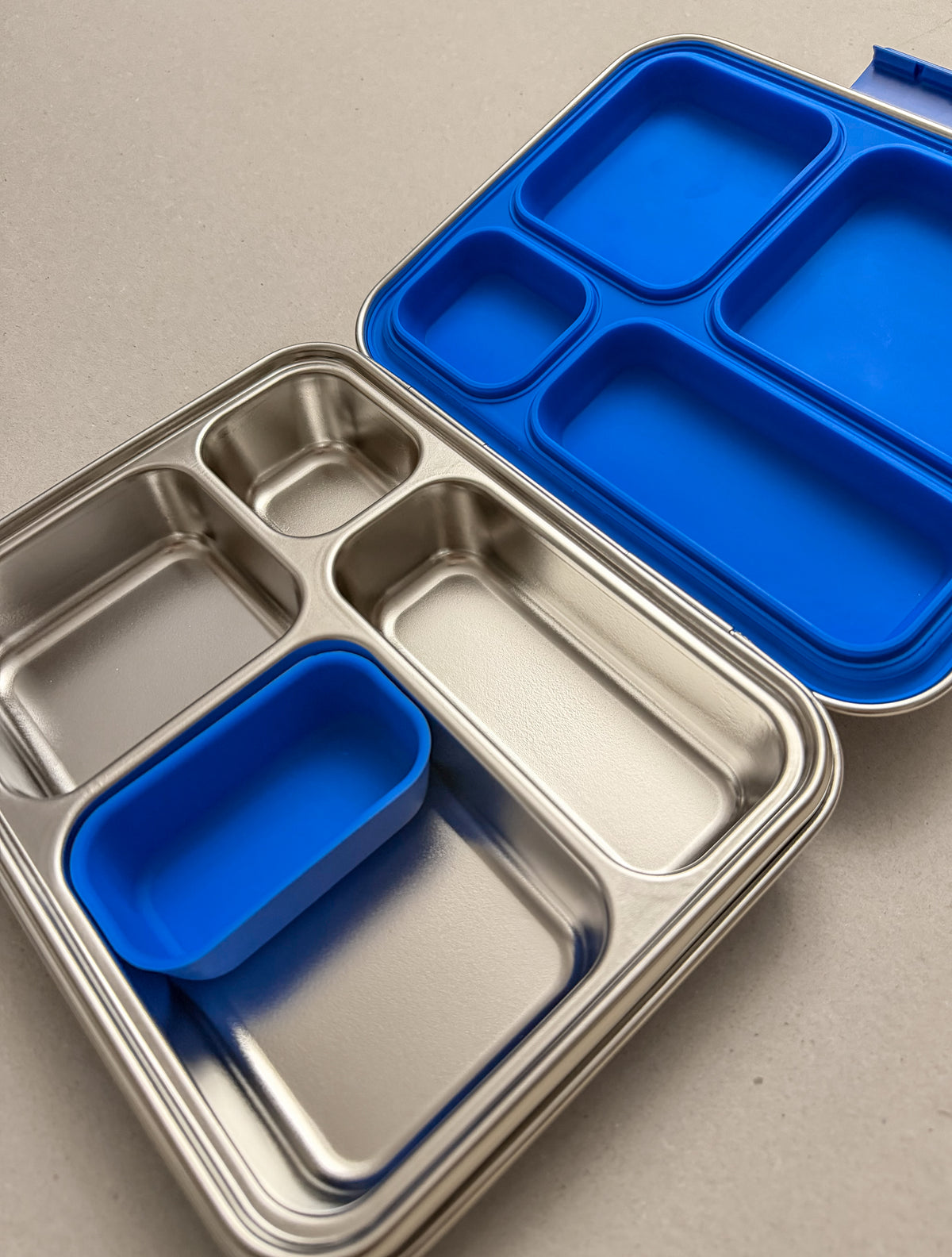 Stainless-steel lunchbox with a silicone seal insert and a snack cup.