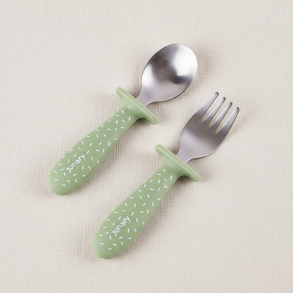 A baby utensil set featuring a spoon and a fork with green speckled pattern handles and silver stainless-steel heads.