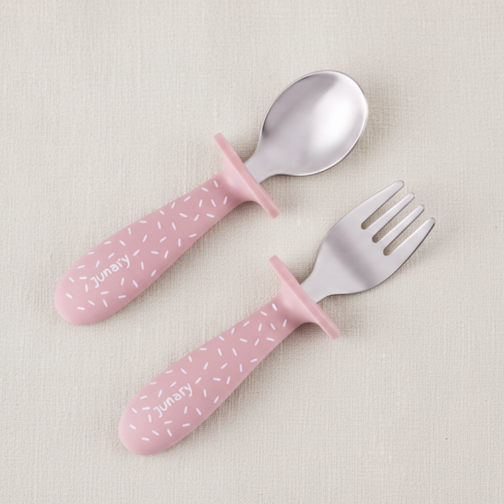 Pink silicone baby spoon and fork set with silver stainless steel heads. Speckles pattern. 