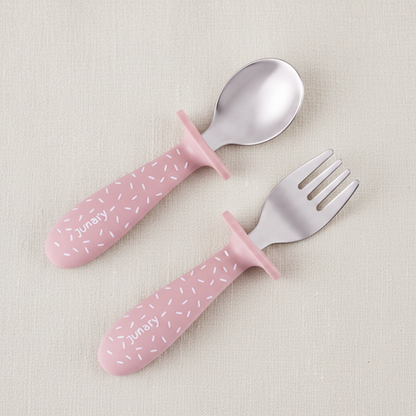 Pink silicone baby spoon and fork set with silver stainless steel heads. Speckles pattern. 