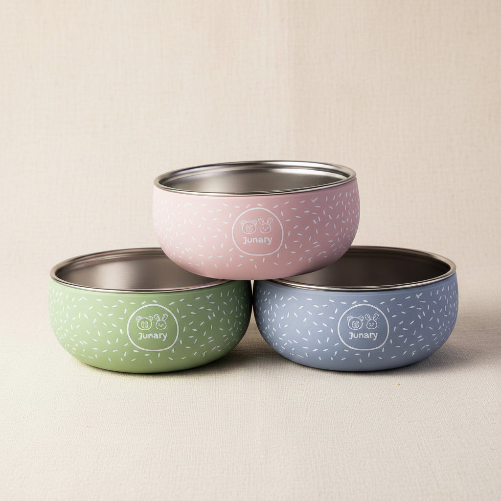Three silicone and stainless-steel bowls with speckled pattern in pink, green, and blue.