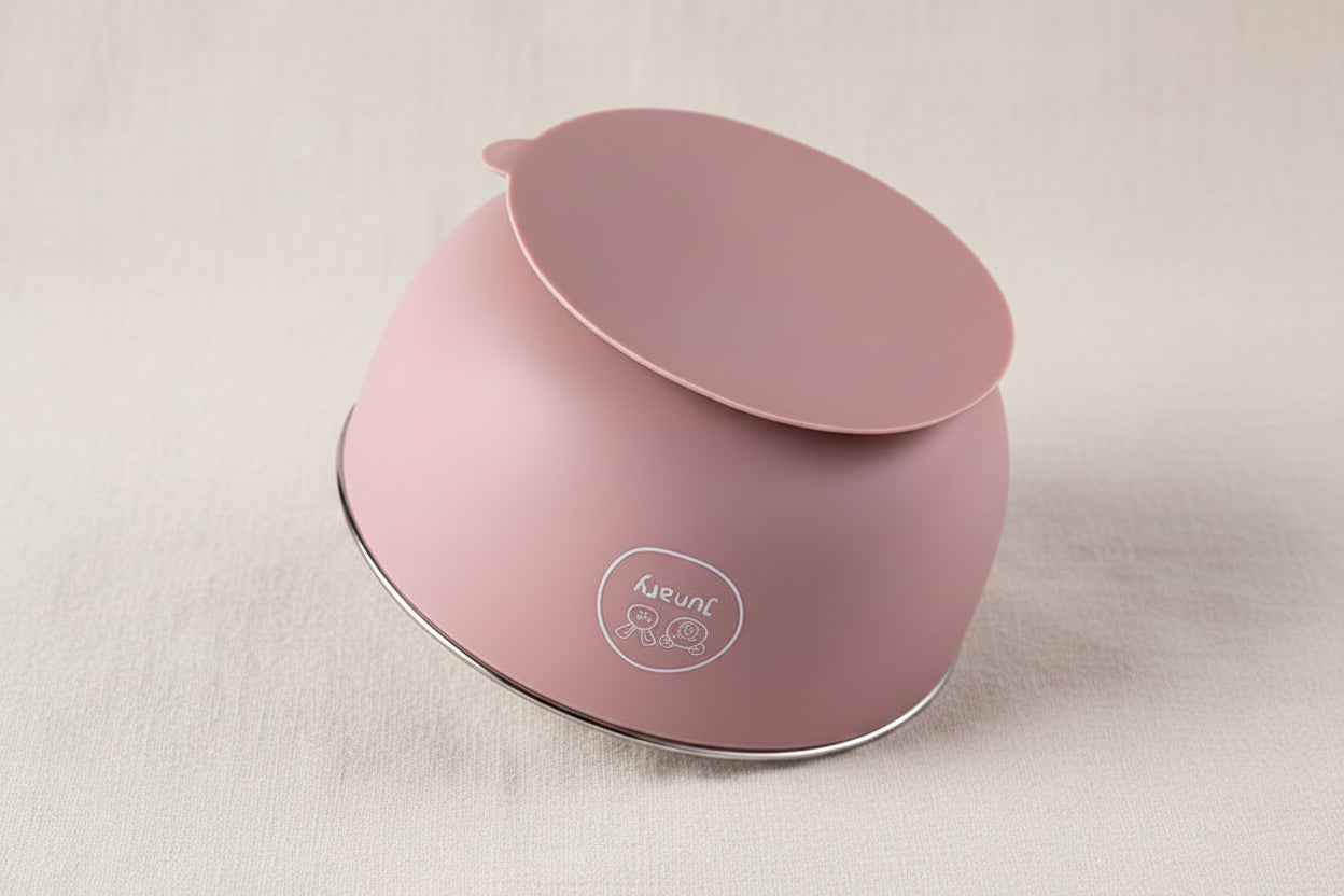 A dusty pink silicone baby feeding bowl with a suction base, shown upside down.