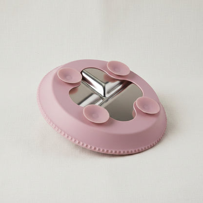 A pink silicone and stainless-steel plate with four suction cups.