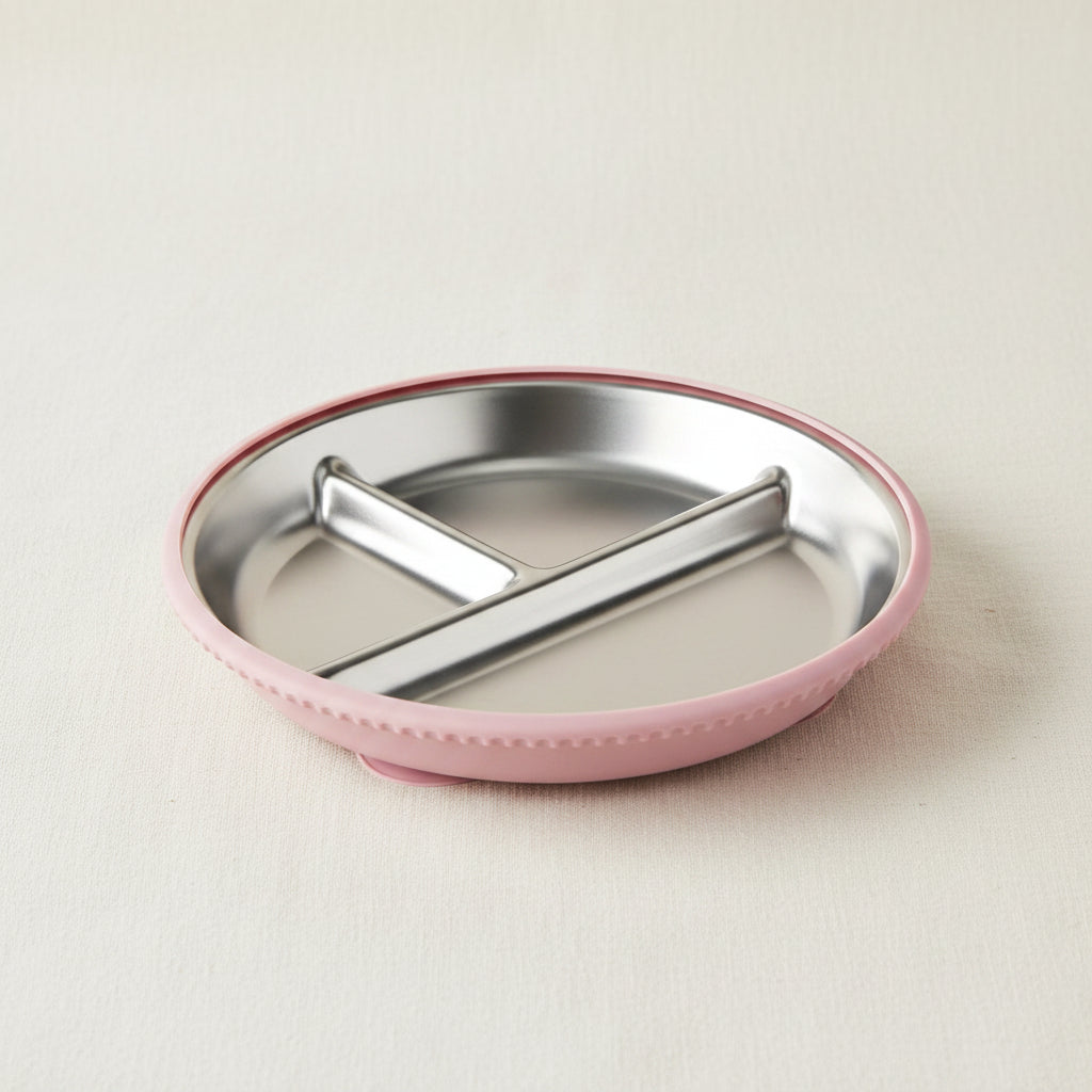 A round divided baby plate with a stainless-steel interior and a pink silicone suction.