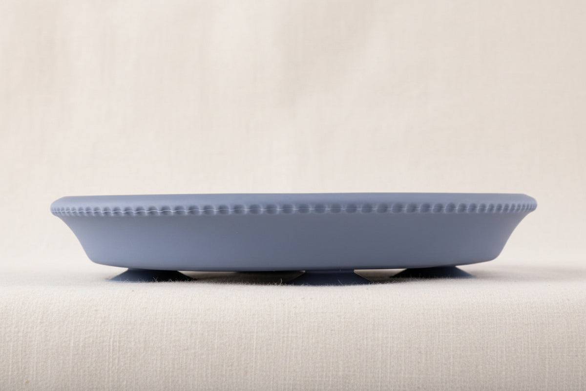 Blue silicone and stainless-steel gripper plate. Side view with suction. 