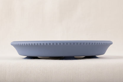 Blue silicone and stainless-steel gripper plate. Side view with suction. 