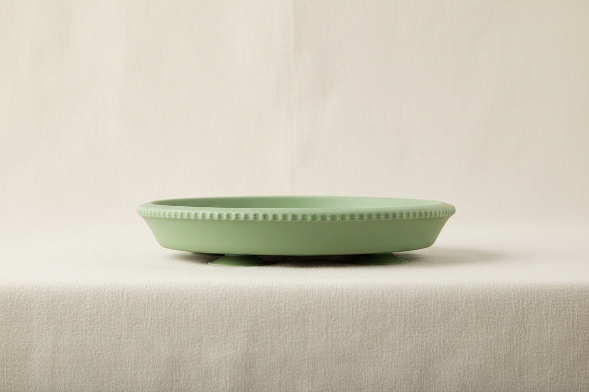 Green silicone and stainless-steel gripper suction plate. Side view.