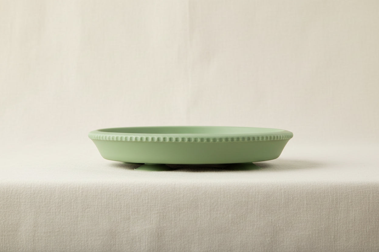 Green silicone and stainless-steel gripper suction plate. Side view.