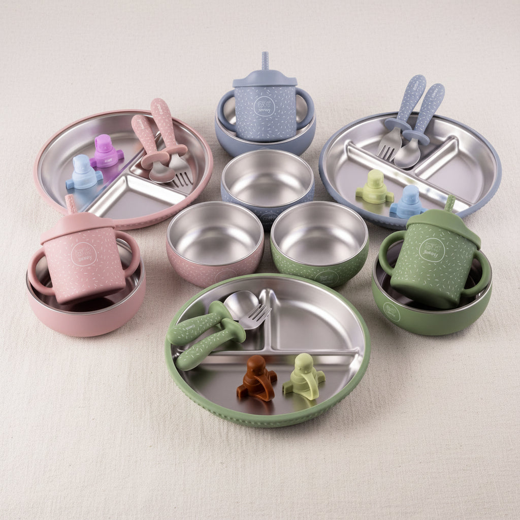 Sets of stainless steel and silicone feeding accessories arranged on a white background, including divided plates, bowls, cups, spoons, forks, blue, and  evergreen.