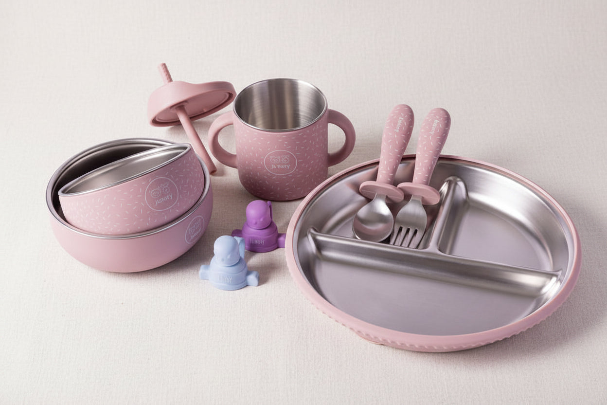 Feeding sets in pink and stainless steel the set includes a divided plate, a handled mug, stacked bowls, a sippy cup with lid, and matching utensils with pink handles.