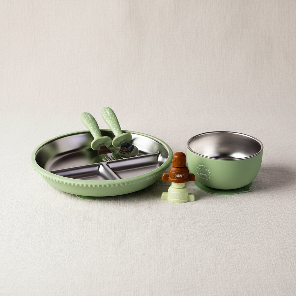 A baby feeding set including a light green silicone-edged divided plate with stainless steel interior, a matching bowl with a stainless steel interior, two green silicone utensils and brown and green pouch toppers.